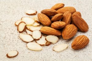 Sliced almonds next to whole almonds