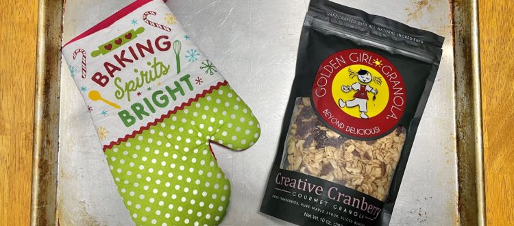 Oven mitt with Creative Cranberry granola bag on a baking tray.