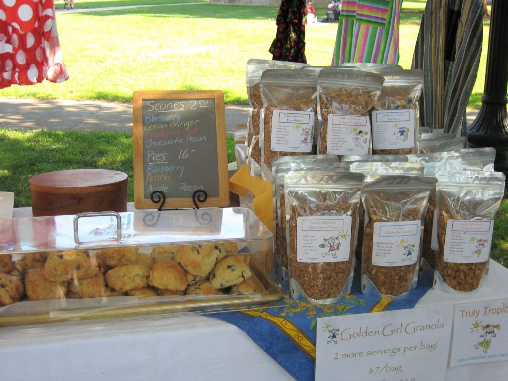 Golden Girl Granola selling products at a farmers' market.