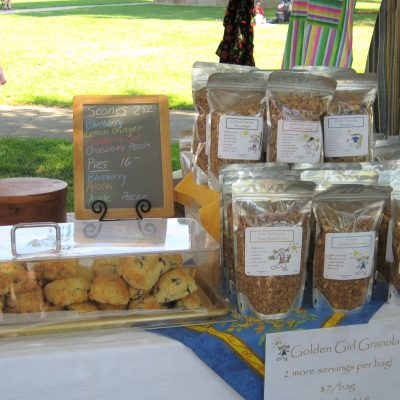 Golden Girl Granola selling products at a farmers' market.
