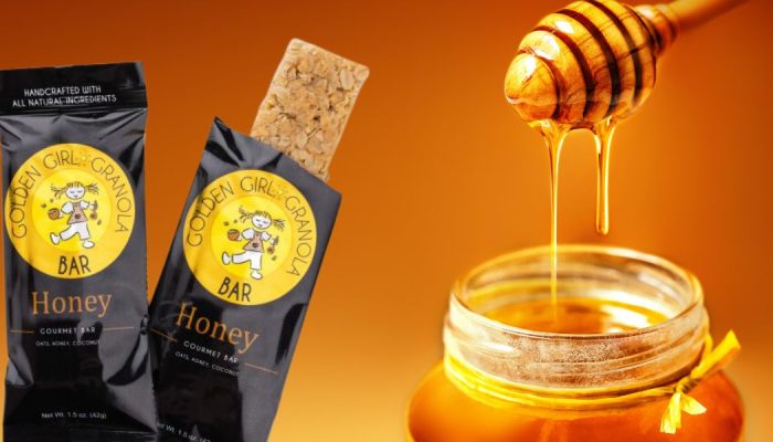 Honey granola bar with honey jar and dipper.